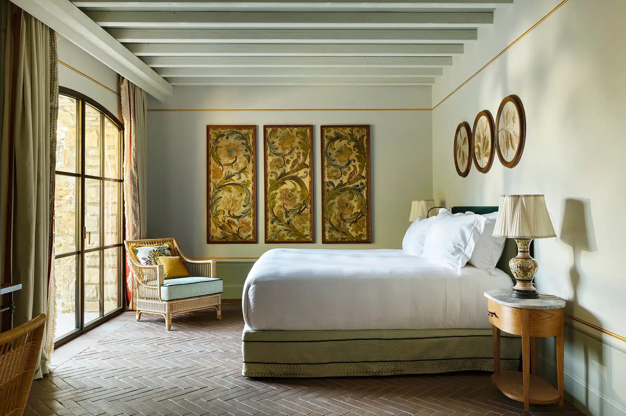 A luxury suite interior with contemporary furniture, art, and a view leading to a private garden terrace.