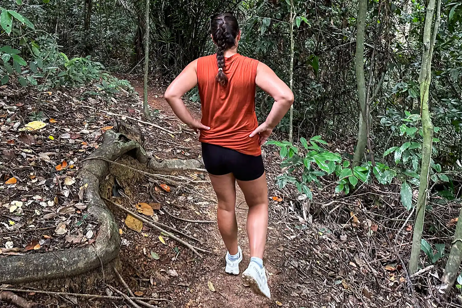 A person in athletic attire standing on a trail, showcasing a comfortable travel backpack for walking.