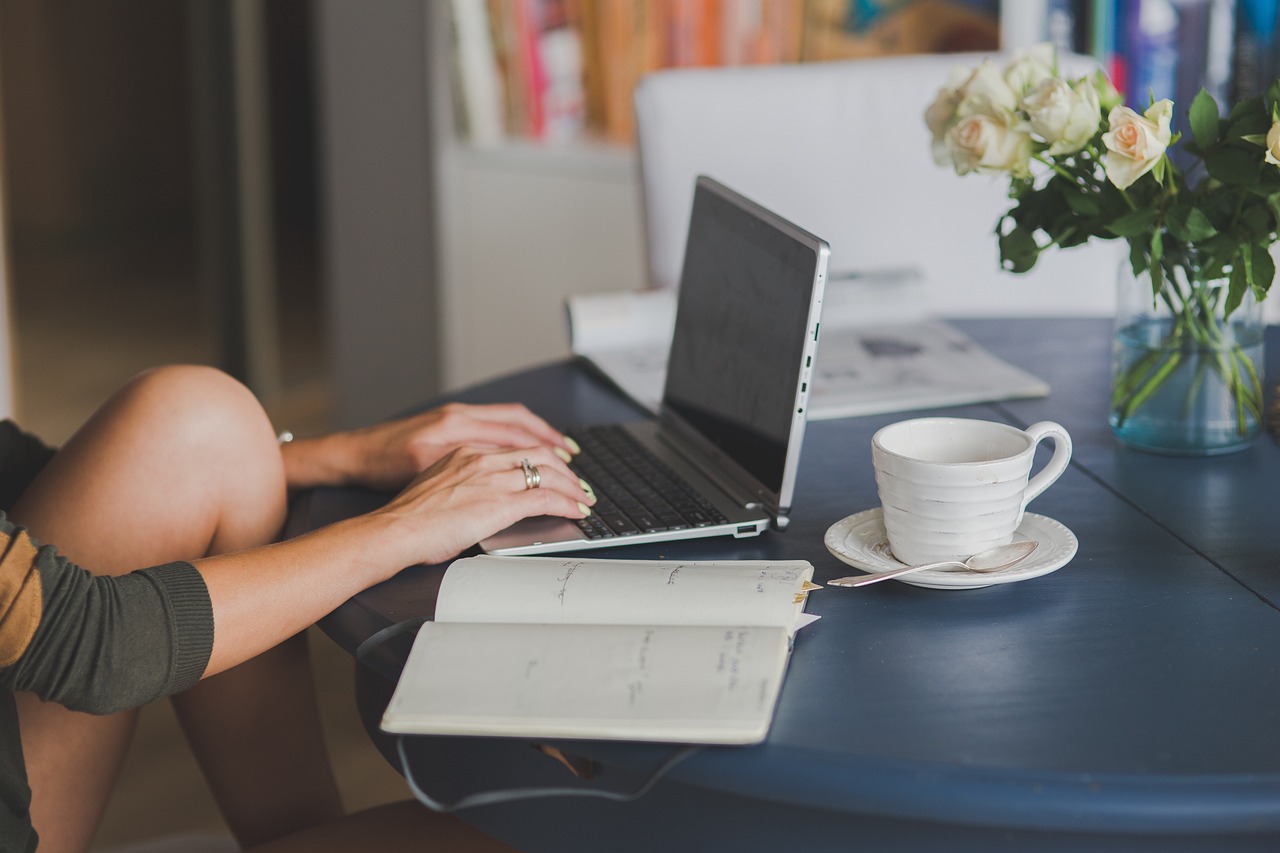 A person using a laptop with a map and a cup of coffee, representing travel planning.