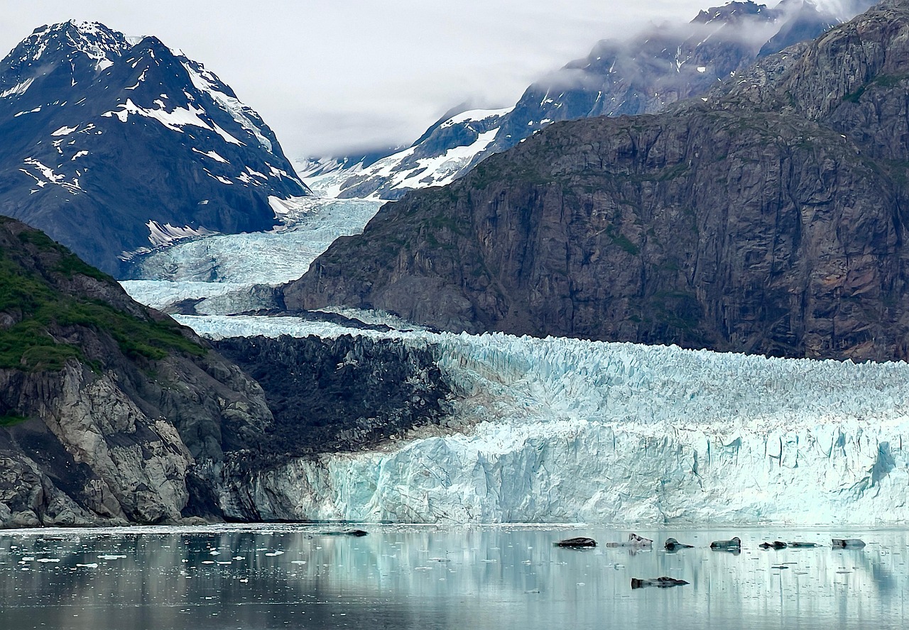 A small bush plane flying over massive glacial crevasses in Alaska.