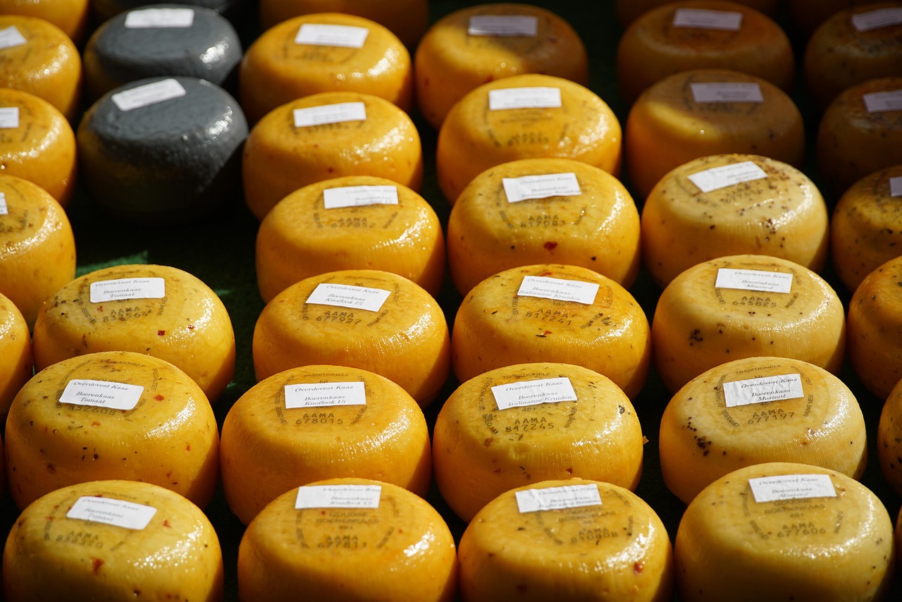 A close-up shot of a local market stall in Aix-en-Provence with olives, herbs, and French cheeses.