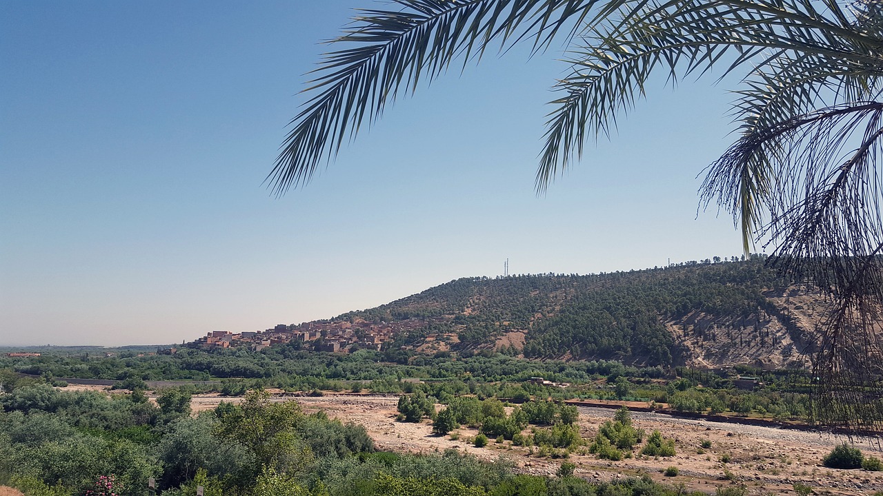 A rooftop terrace overlooking the city of Marrakech with mountains in the distance.