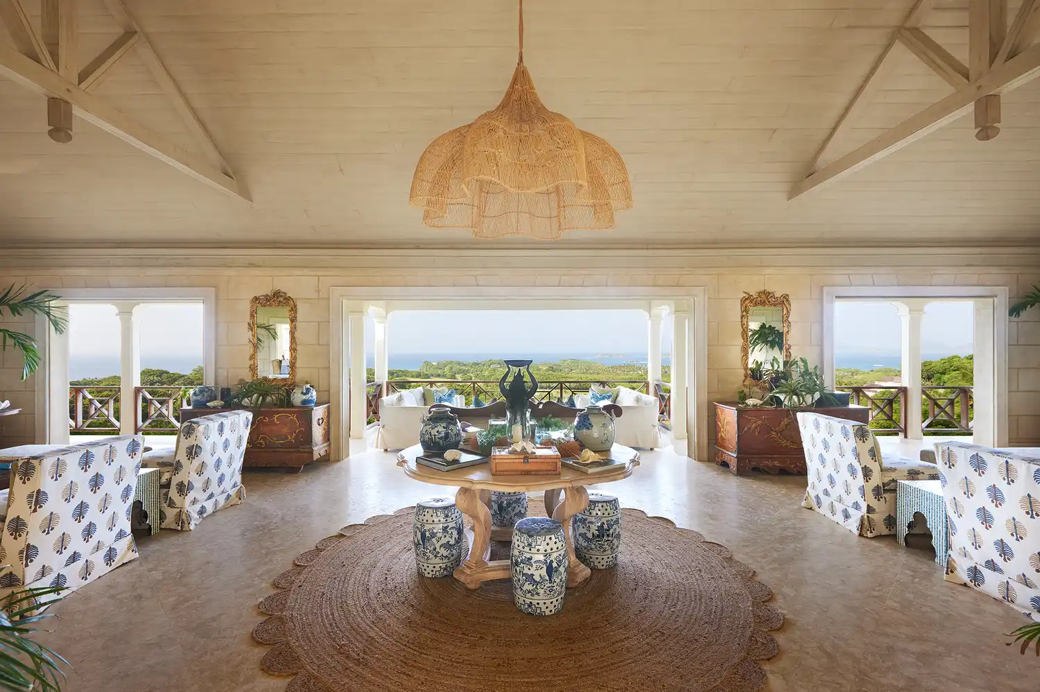 Modern and stylish interior of a luxury villa with large windows offering a view of tropical greenery.