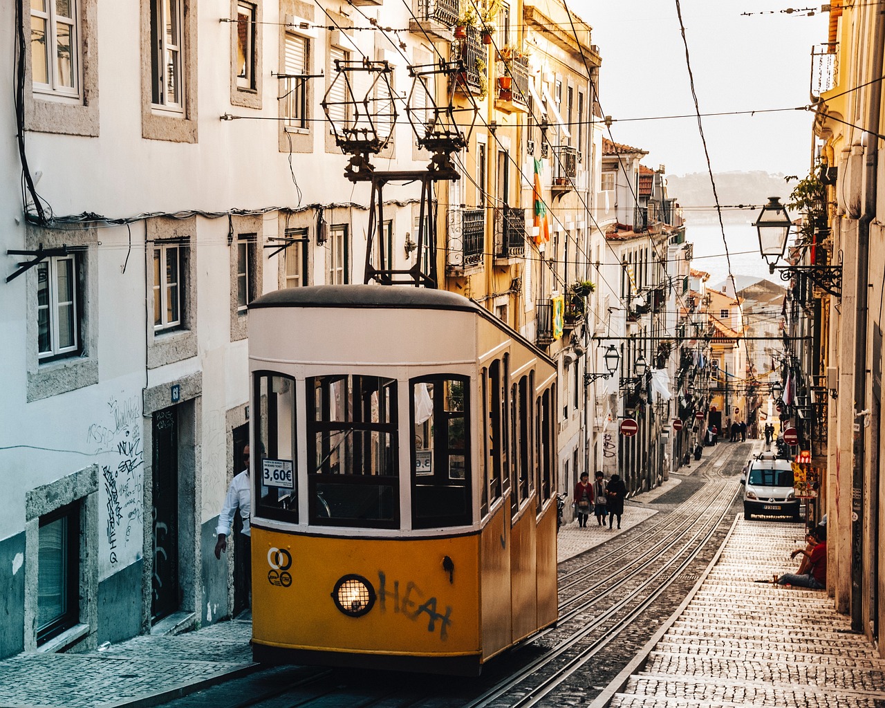 A colorful vintage-style trolley bus driving through a mountain town street.