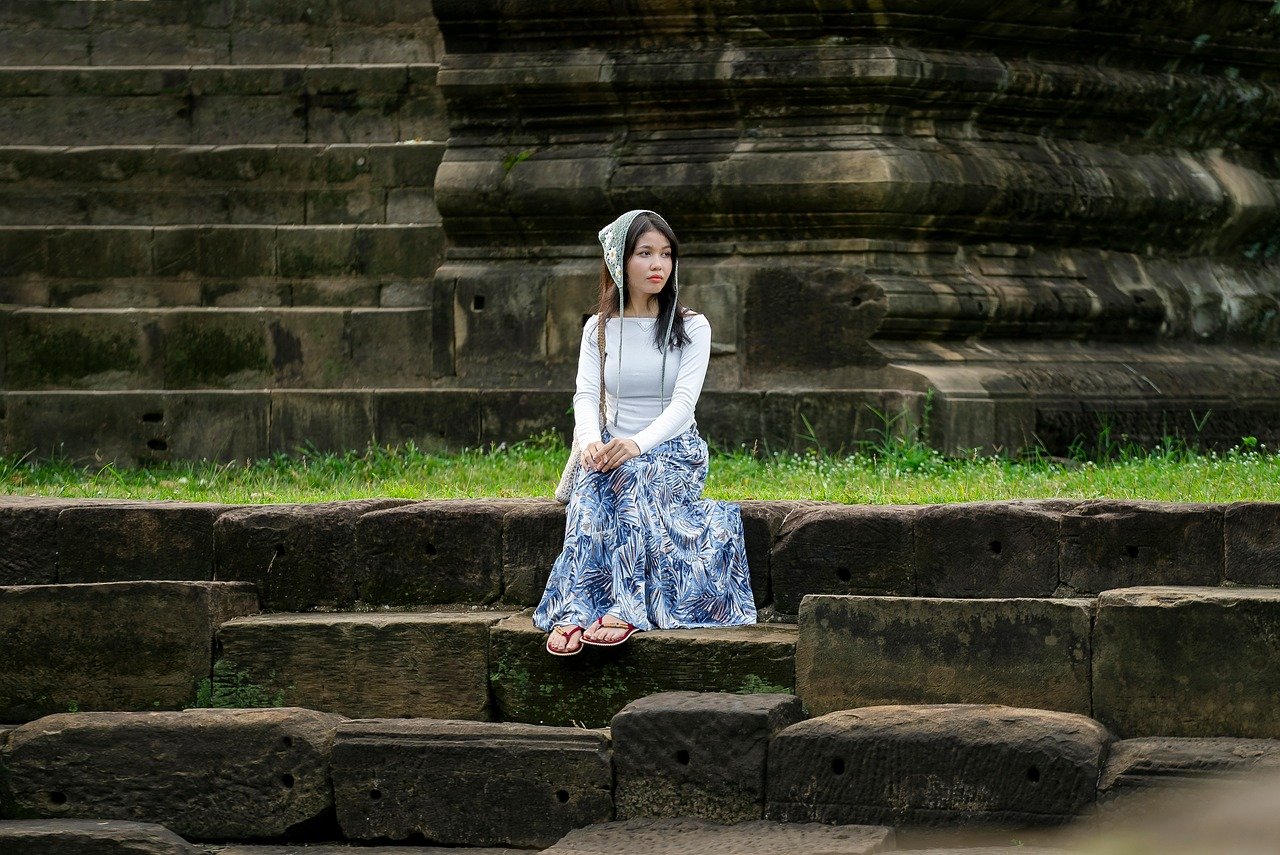 A woman wearing a white pleated skirt and a polo shirt in a sporty setting.