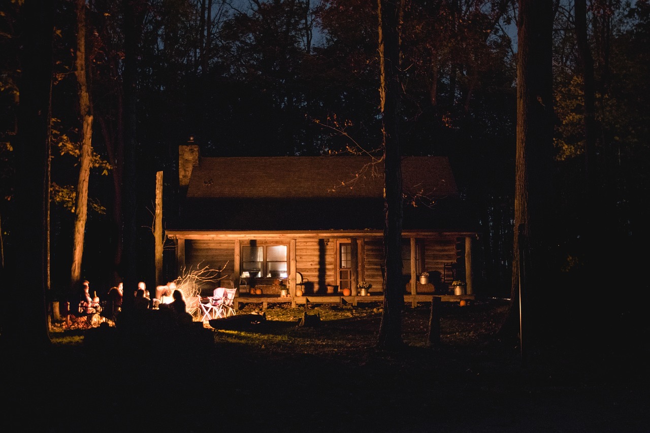 A family roasting marshmallows around a campfire at a glamping site