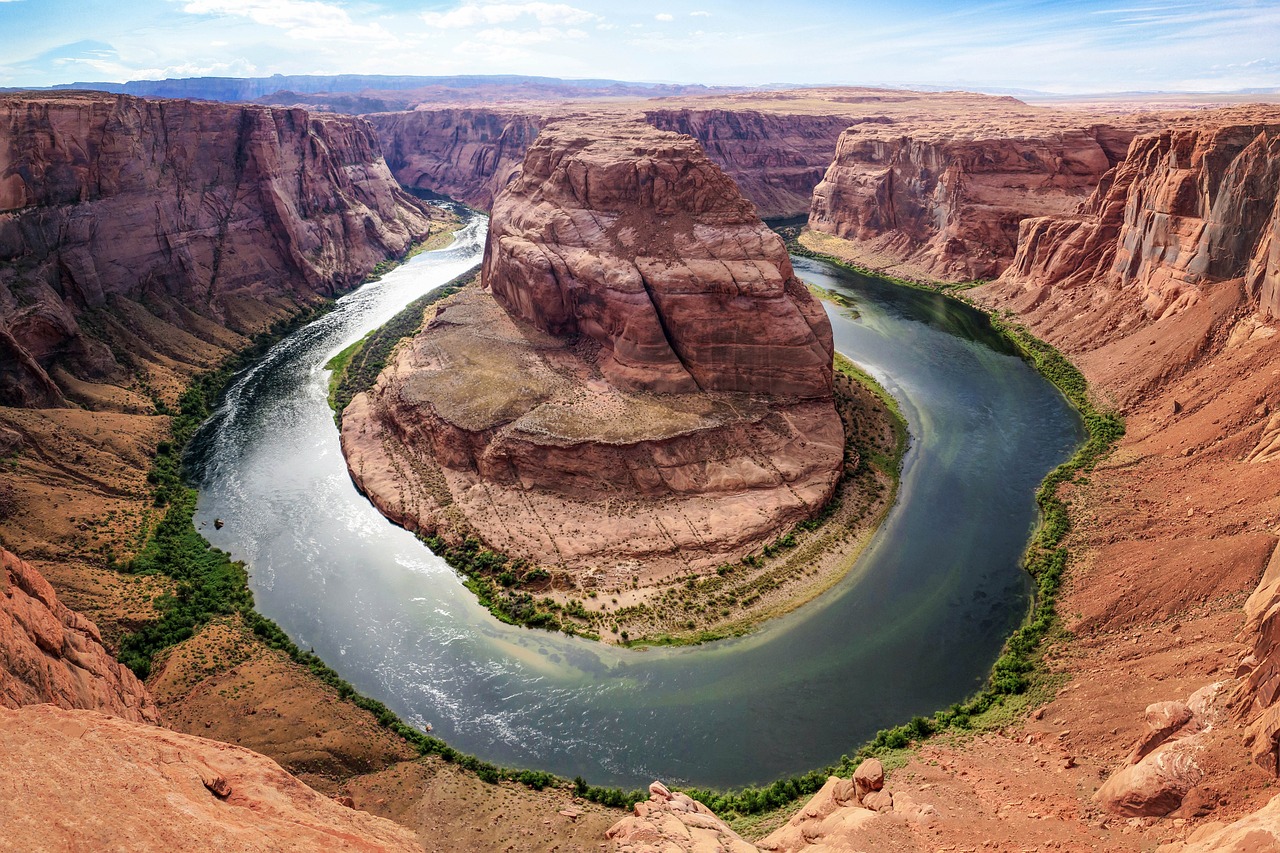 A single person standing on a cliff overlooking a vast red rock canyon