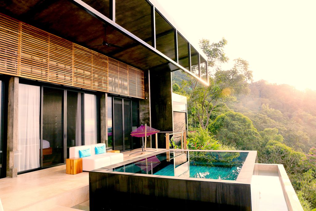 An infinity pool at Kura Boutique Hotel overlooking the dense tropical rainforest and Pacific coastline.