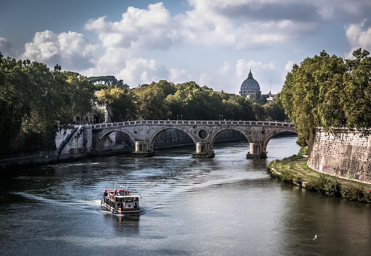 A golden sunset over the Tiber River with the silhouette of Castel Sant'Angelo