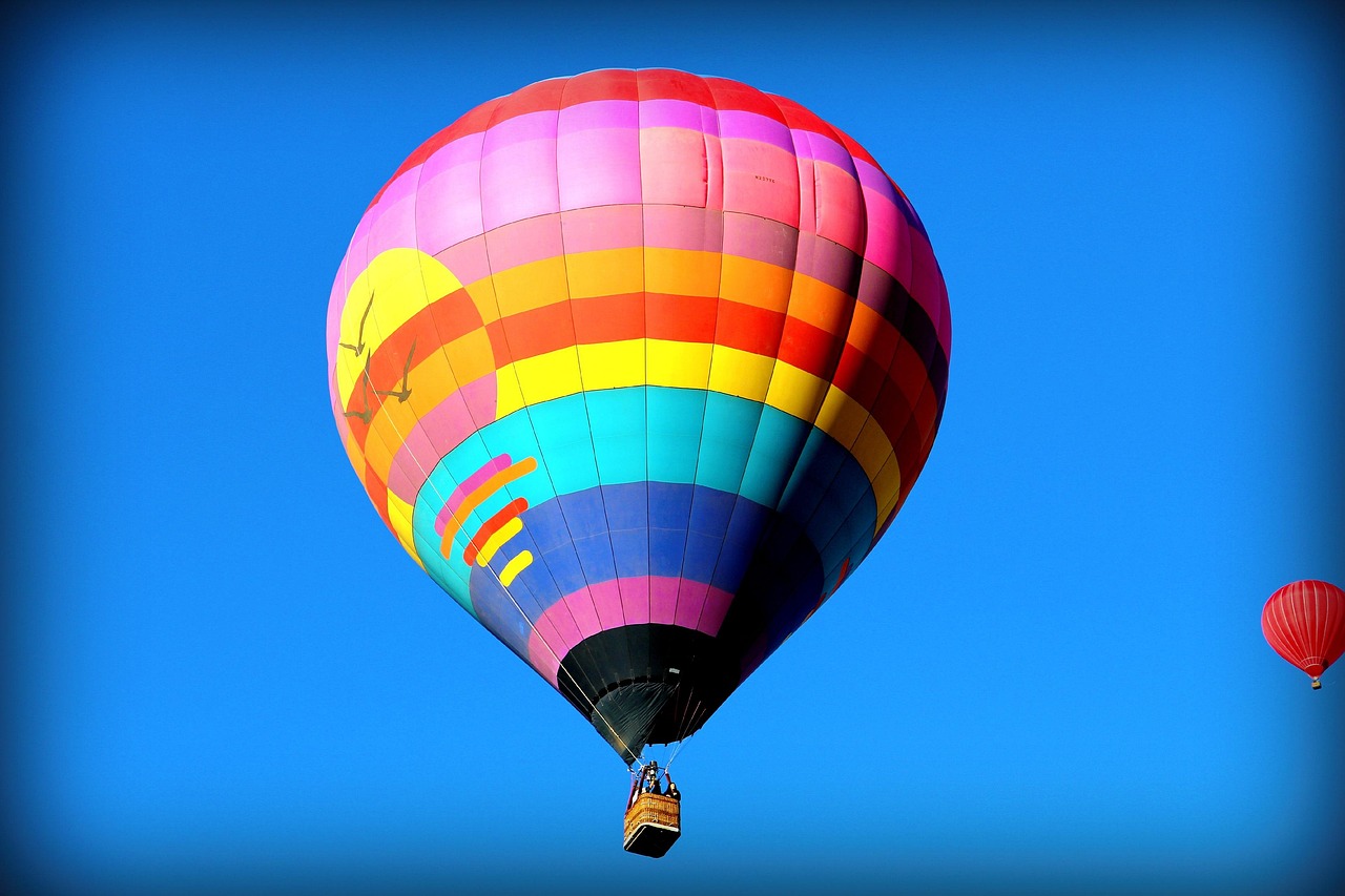 A vibrant sky filled with hundreds of uniquely shaped and colored hot air balloons.