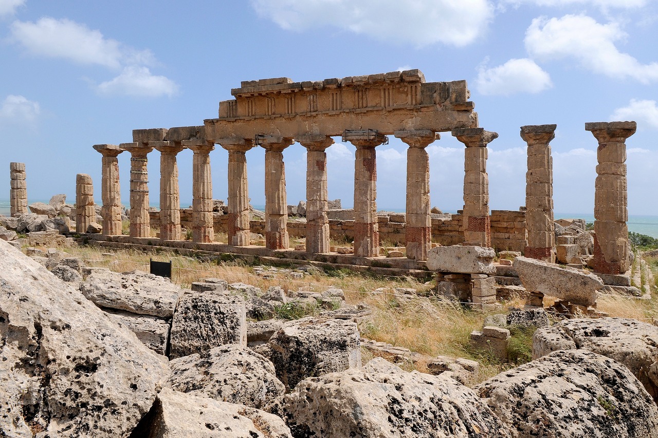 The ruins of an ancient Greek theater in Taormina with Mount Etna smoking in the background.