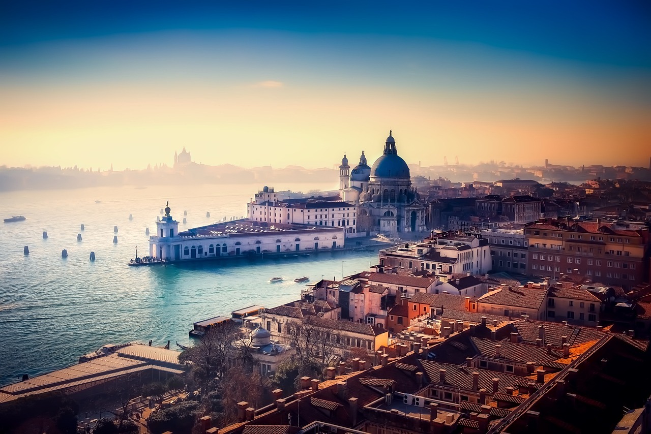 A quiet Venice canal shrouded in winter mist with a lone gondola.