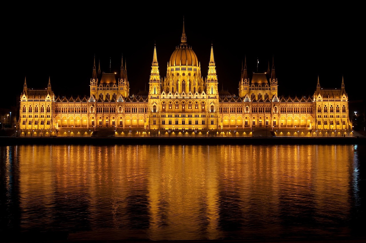 The Hungarian Parliament building illuminated at night across the Danube