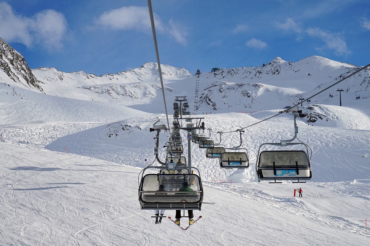 Wide open groomed ski runs at a major Colorado resort under a blue sky.
