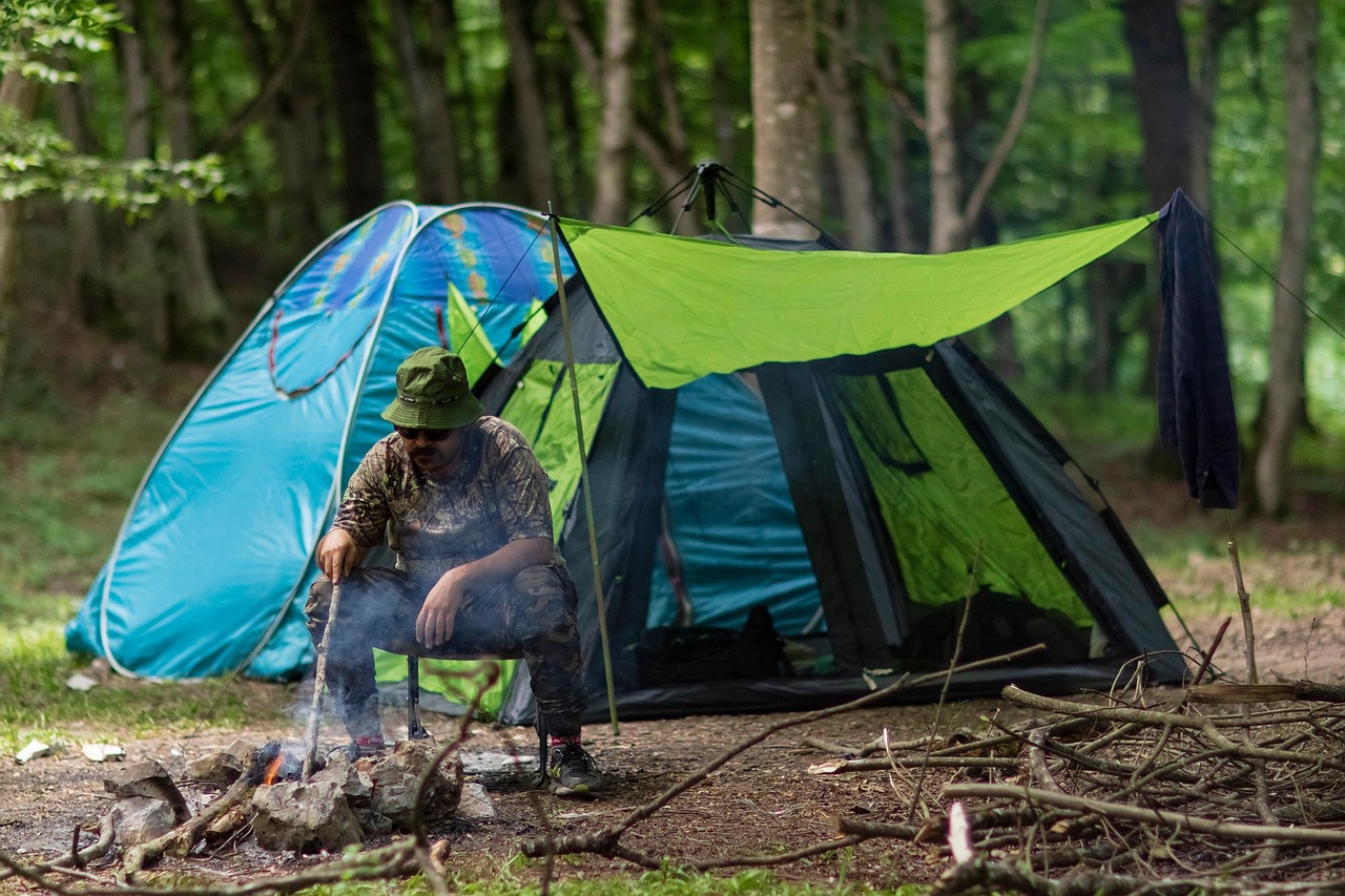 A folded camping chair strapped to the side of a hiking backpack.