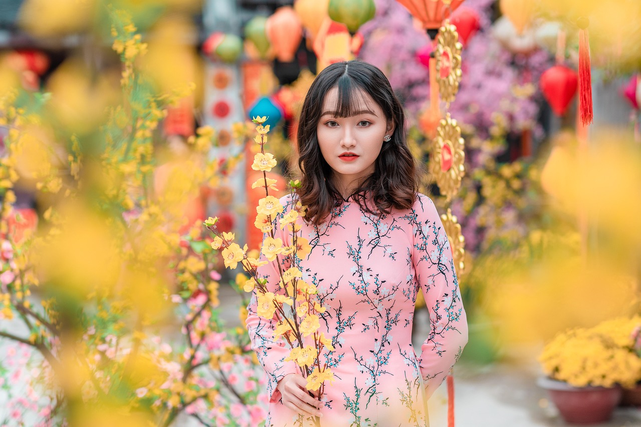 A woman in a botanical print midi dress standing near tropical palm trees.
