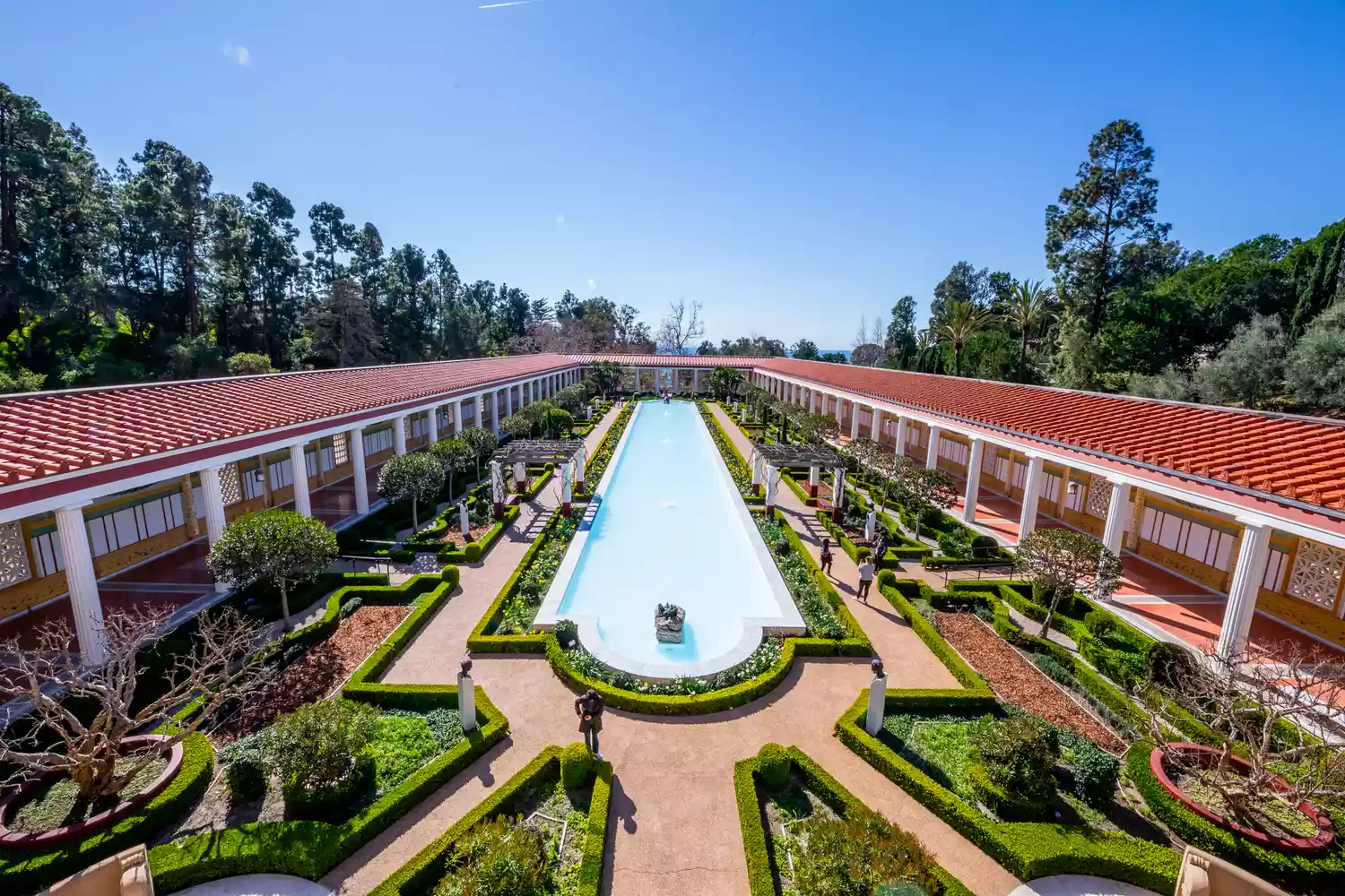 A long reflective pool and lush gardens surrounded by Roman-style colonnades at the Getty Villa.