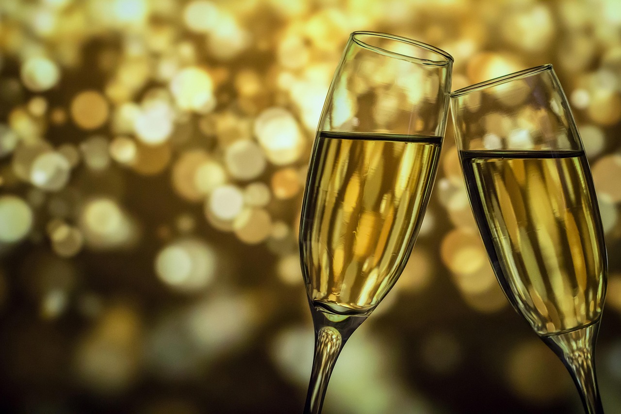 Two crystal champagne flutes being toasted in a luxurious setting.