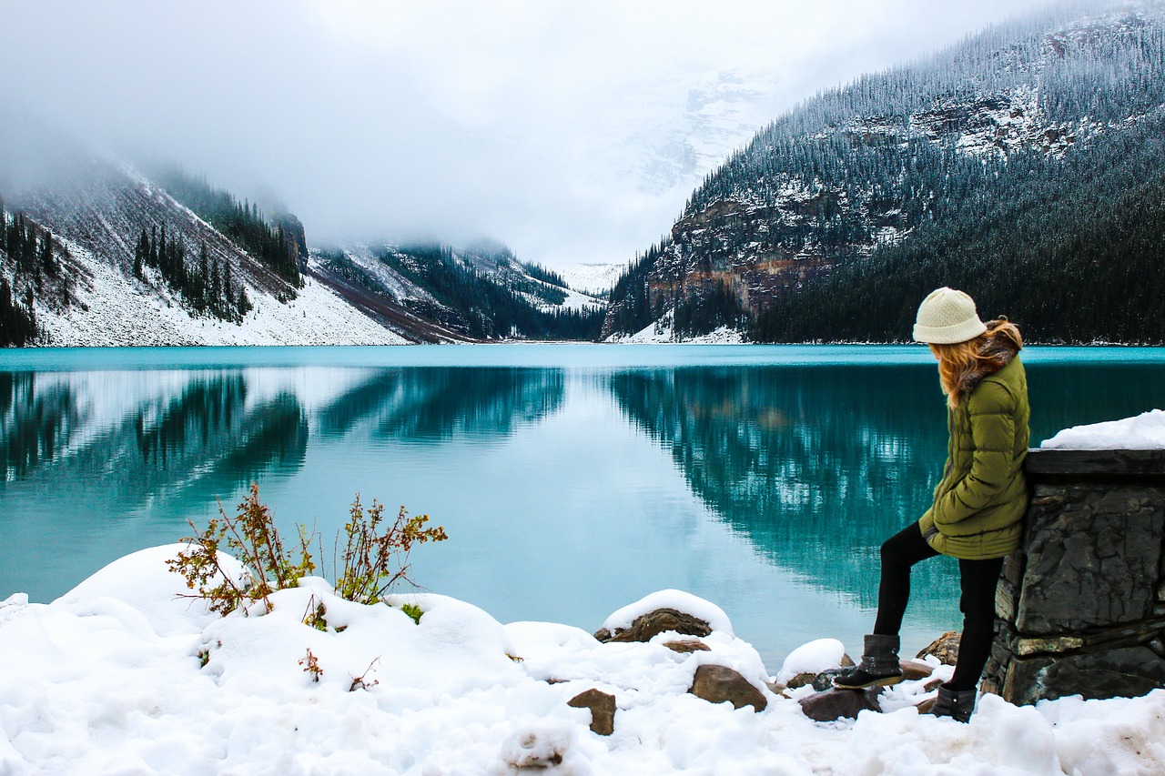 A person wearing heavy winter boots and thermal gear standing in deep snow.