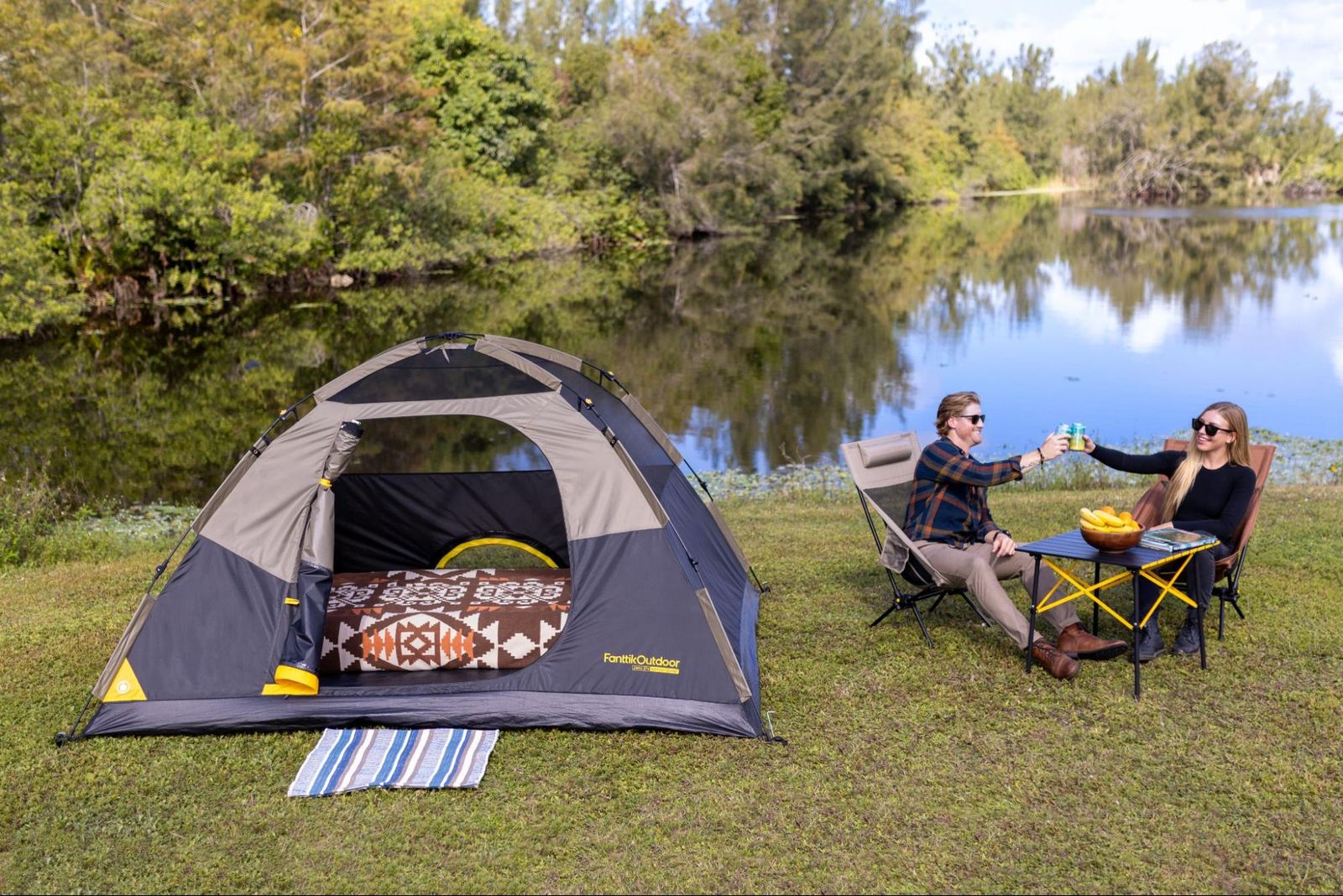 An adult relaxing in a camping chair next to a well-organized tent setup.