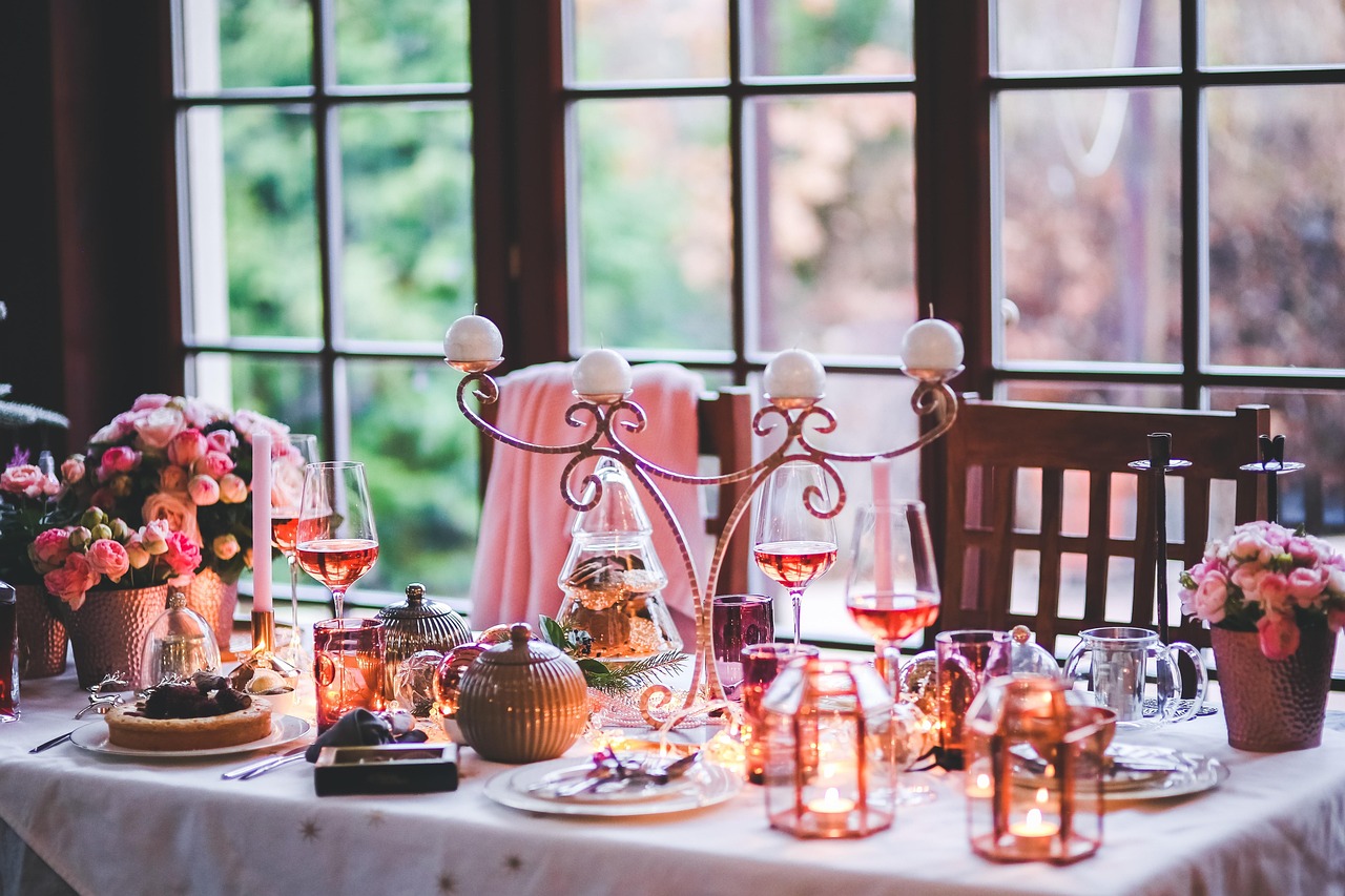 A candlelit dinner table for two set inside a wooden cabin with wine and gourmet pasta.