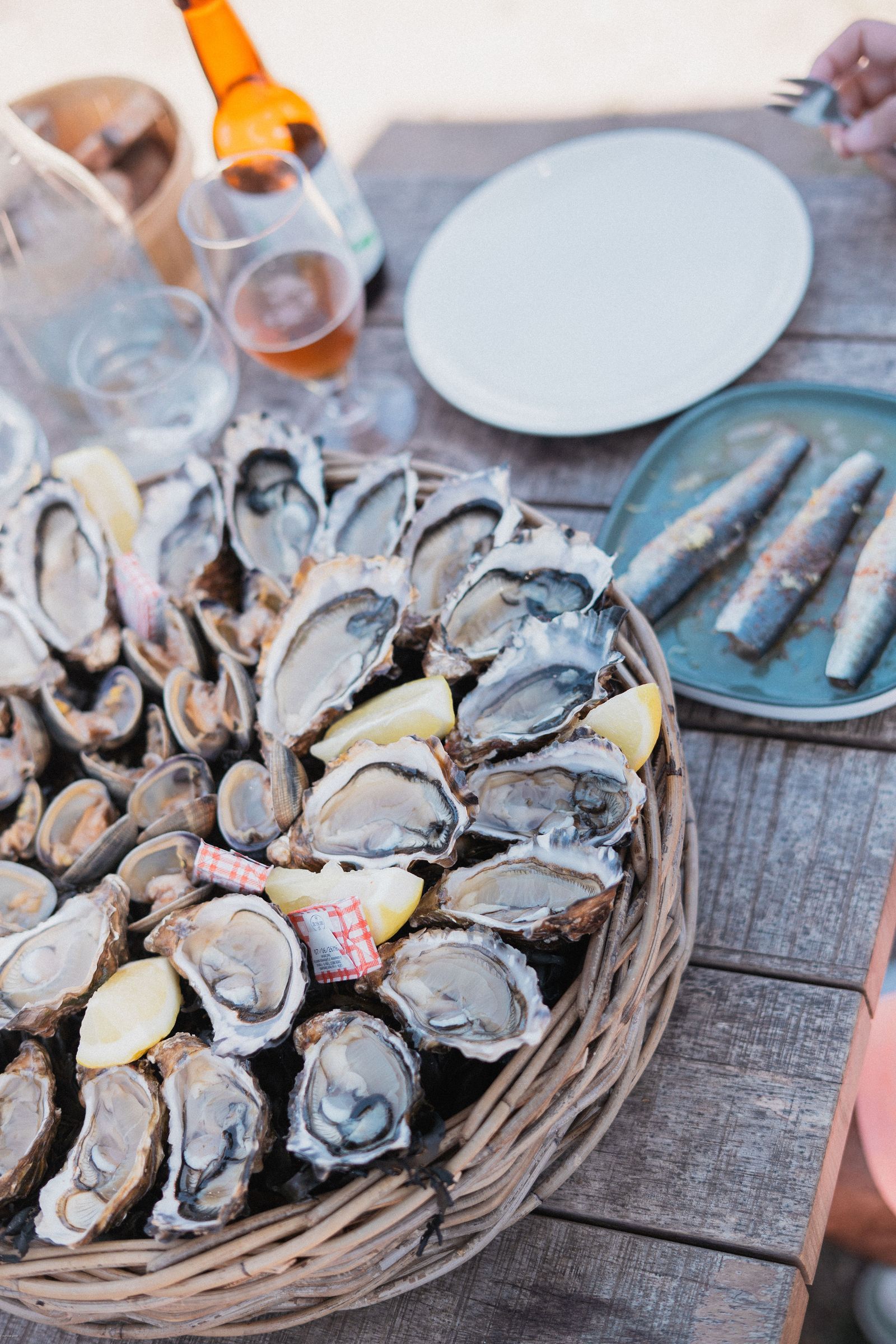 Fresh oysters and local seafood served on a plate at an outdoor table.