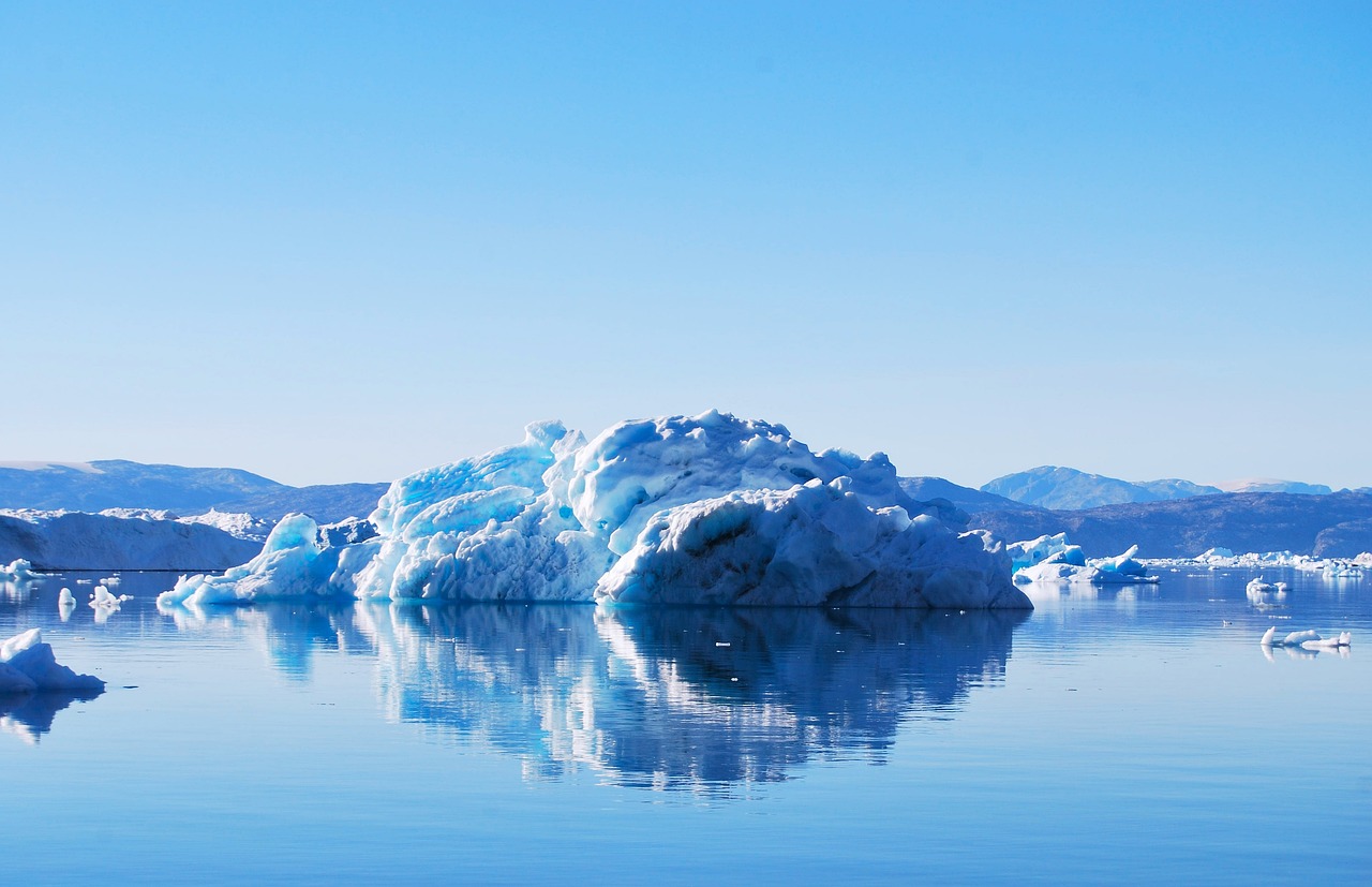 Large icebergs floating in a deep blue fjord in Greenland