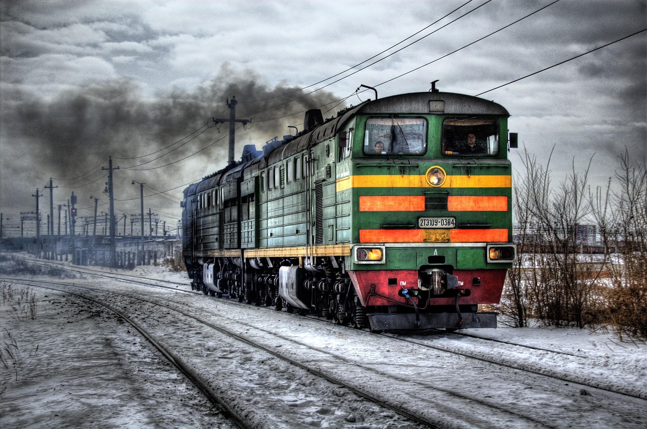The red Glacier Express train crossing a stone viaduct in a snowy mountain landscape.
