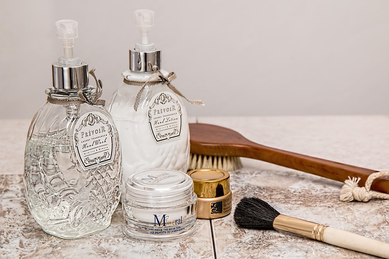 A variety of small skincare containers organized on a clean bathroom counter.
