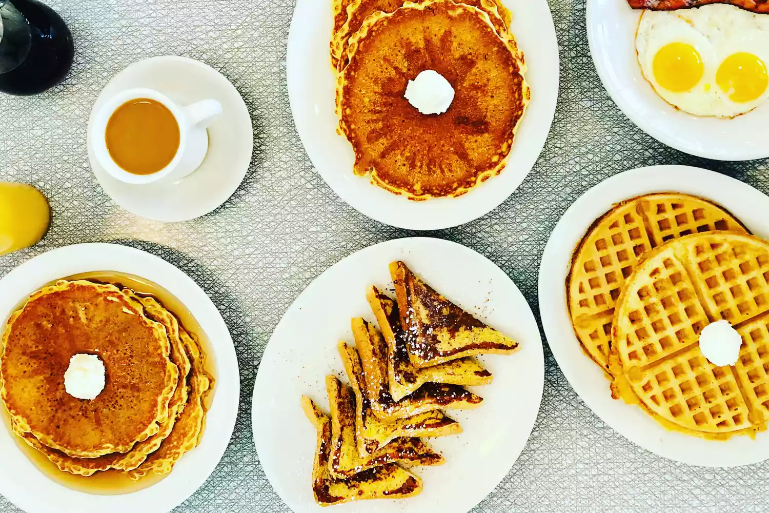 A traditional American breakfast spread with pancakes and eggs at a diner.