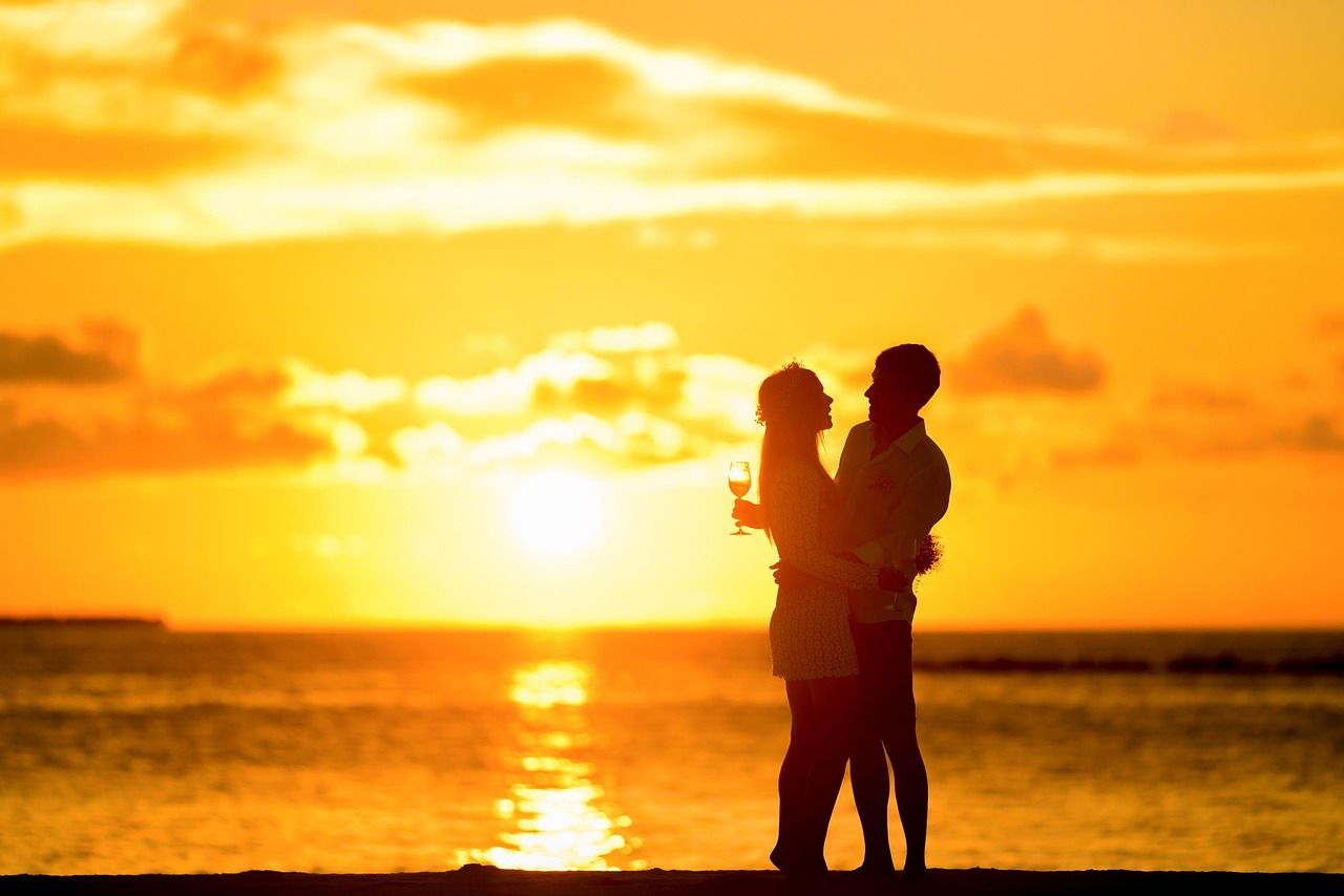 Couple enjoying a private dinner on a beach at sunset