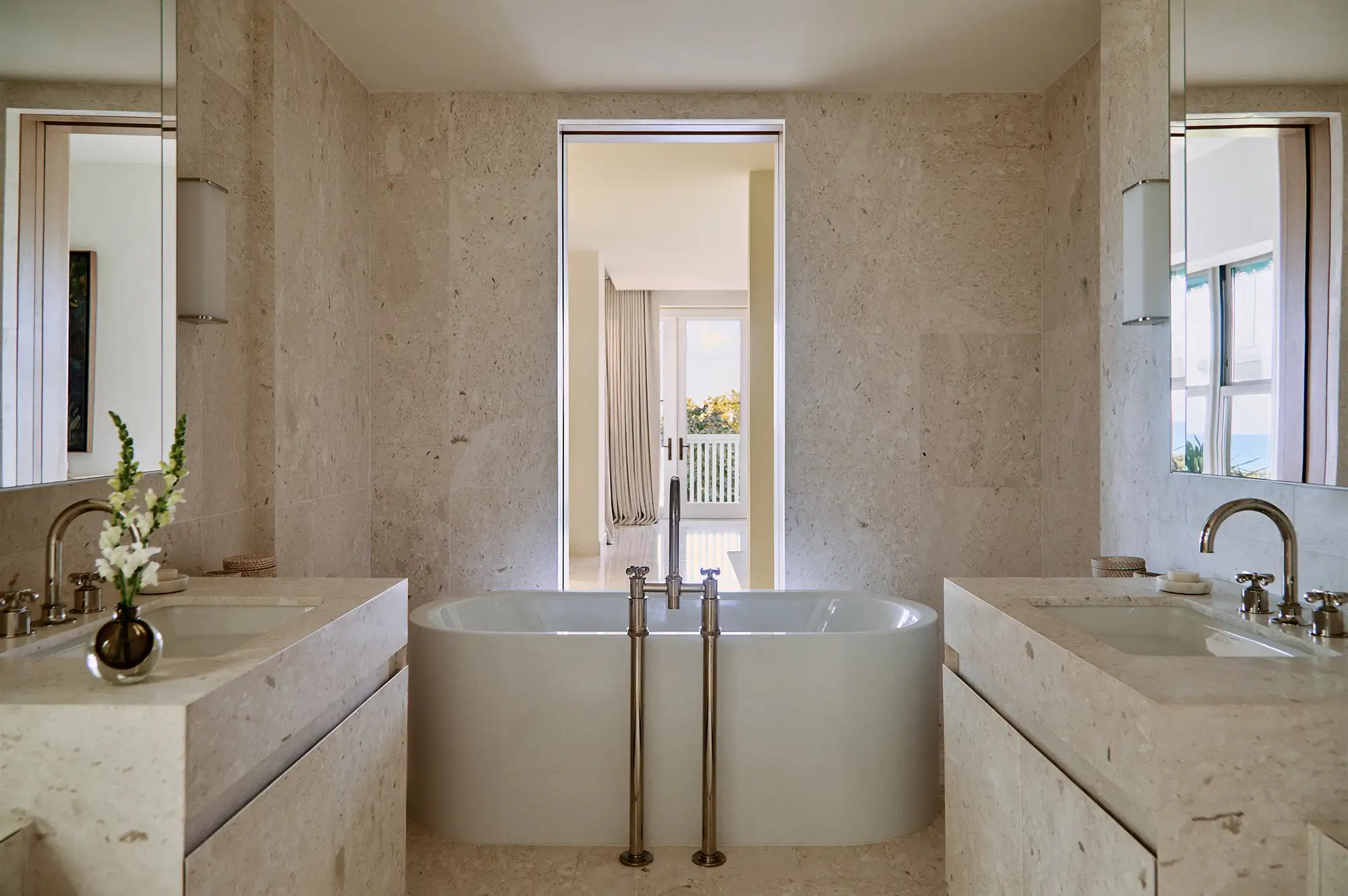 A bright luxury bathroom with a freestanding tub and expansive windows letting in natural light.