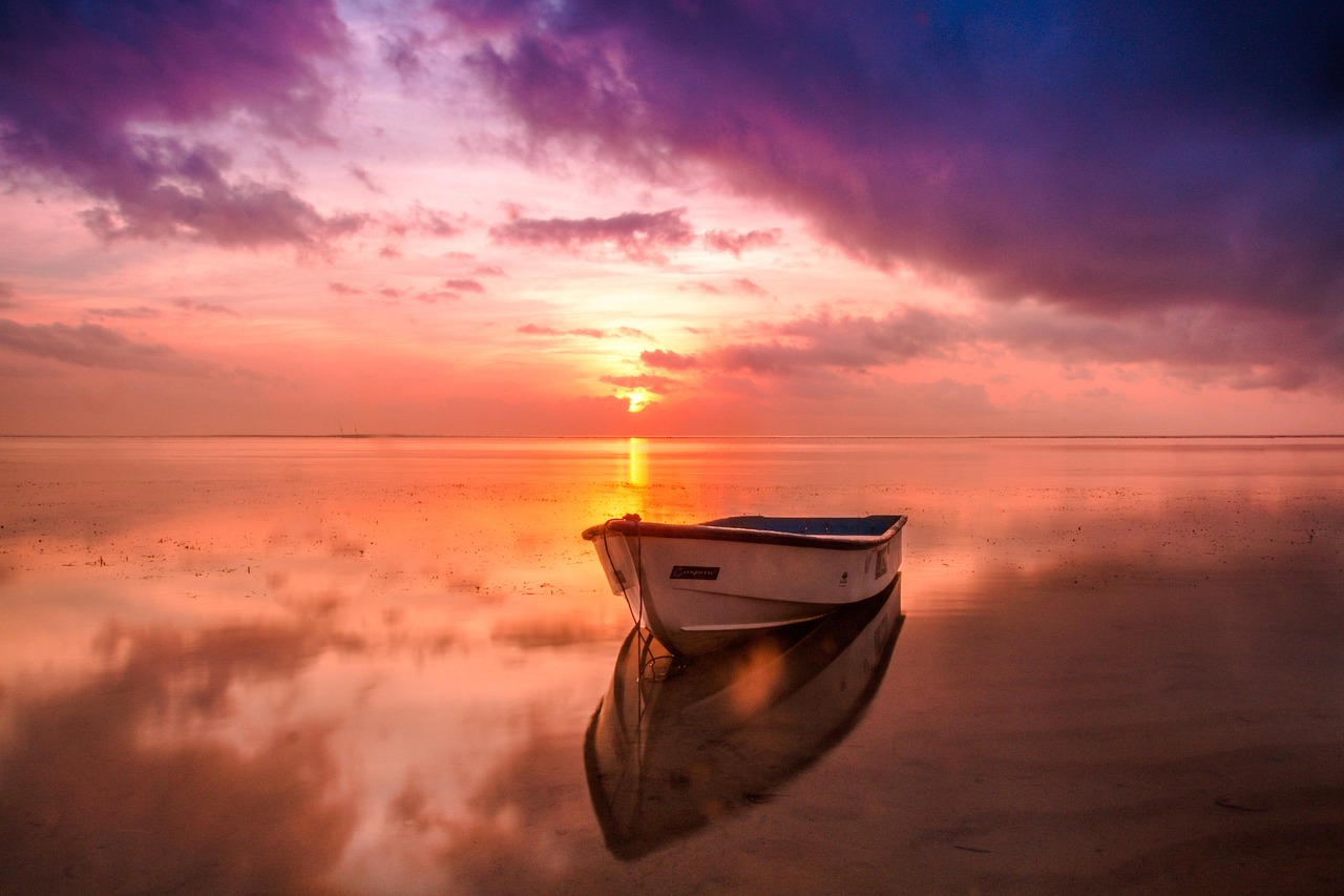 The sun rising over a calm ocean beach with golden light