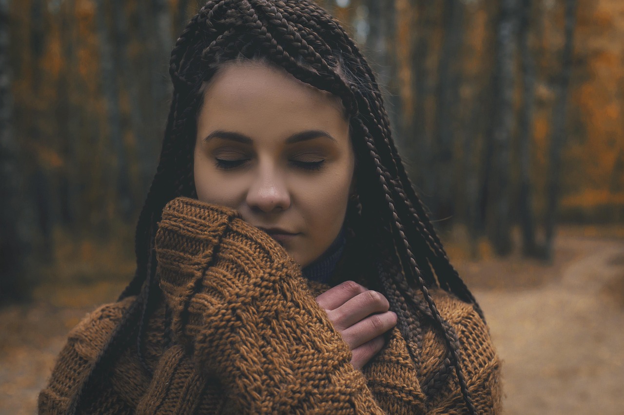 A woman with eyes closed practicing deep breathing to stay calm.